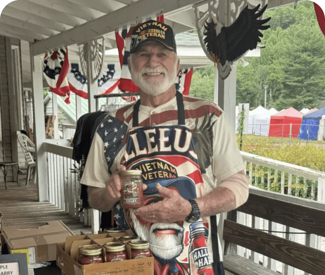 Man holding jar at outdoor market stall.