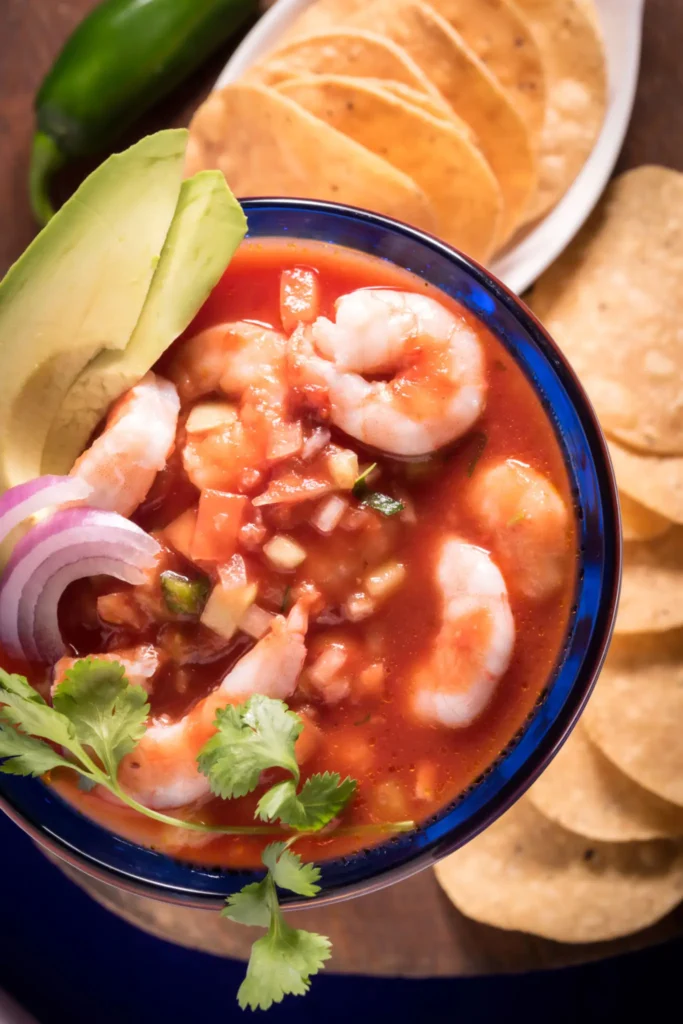 A bowl of shrimp ceviche garnished with avocado and cilantro.