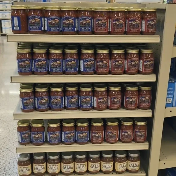 Supermarket shelf filled with jars of salsa